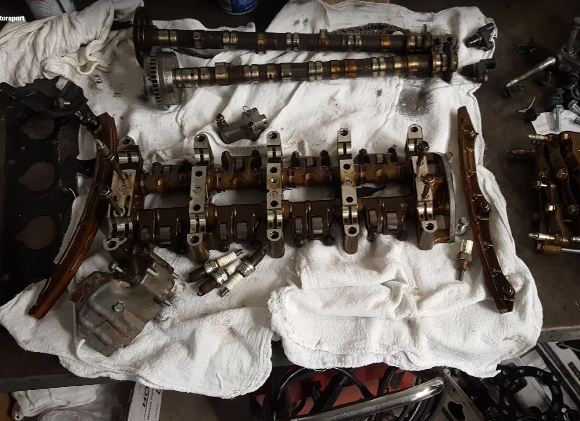 Engine parts laid out on a white cloth, possibly indicating maintenance or repair work in progress